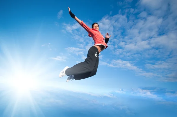 Spor kadın Jumping ve gökyüzü ve güneş üzerinde sinek — Stok fotoğraf