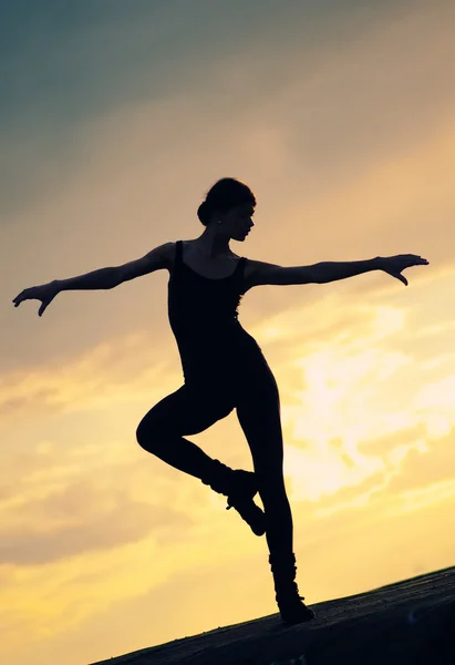 Silhouet van dansende vrouw over zonsondergang. Yoga — Stockfoto