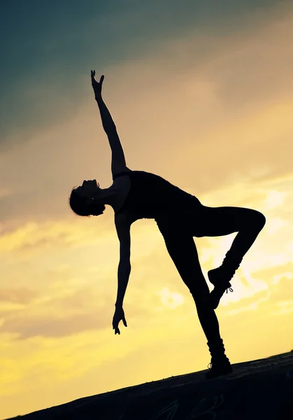 Силуэт танцующей женщины на закате. Йога — стоковое фото