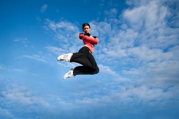 Sportovní žena skákat a létat nad sky — Stock fotografie