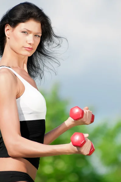 महिला डंबेलसह व्यायाम करत आहे — स्टॉक फोटो, इमेज