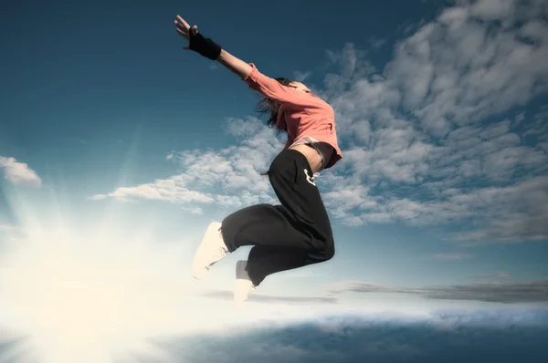 Sport vrouw springen en vliegen over hemel en zon — Stockfoto