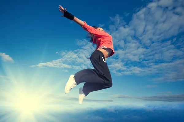 Sport vrouw springen en vliegen over hemel en zon — Stockfoto