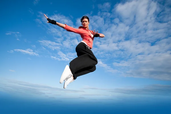 Spor kadın Jumping ve gökyüzü üzerinde sinek — Stok fotoğraf