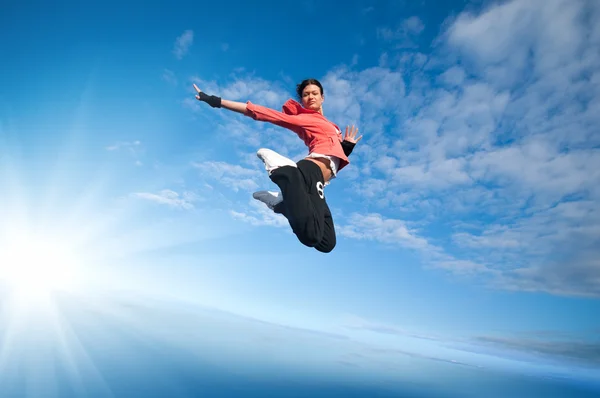 Sport kvinna hoppa och flyga över himlen och solen — Stockfoto