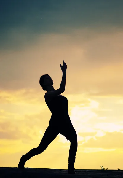 Silhouet van dansende vrouw over zonsondergang. Yoga — Stockfoto
