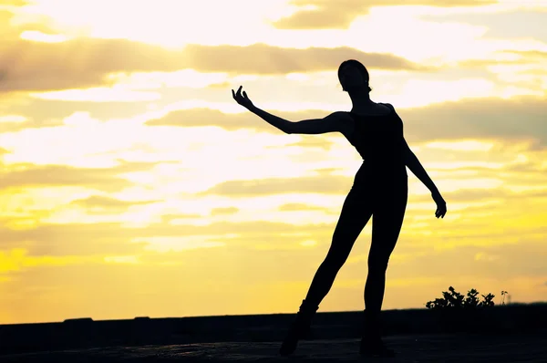 Günbatımı üzerinde dansçı kadın silüeti. Yoga — Stok fotoğraf