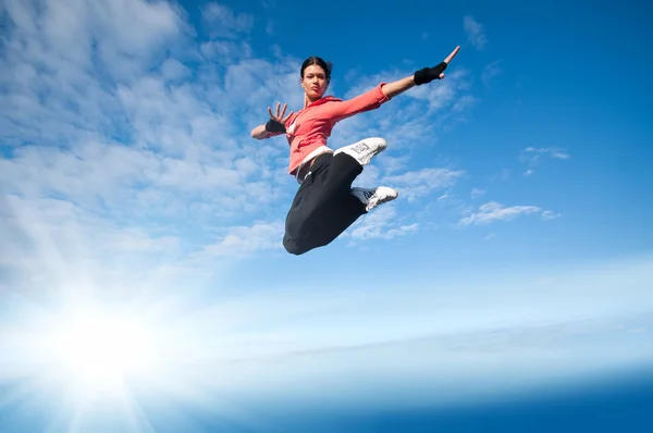 Deporte mujer saltando y volar sobre el cielo y el sol — Foto de Stock