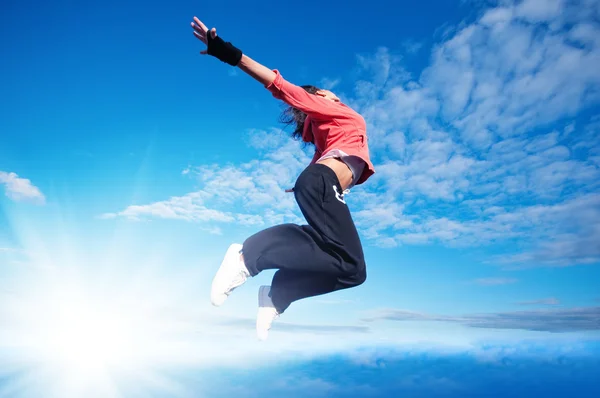 Spor kadın Jumping ve gökyüzü ve güneş üzerinde sinek — Stok fotoğraf