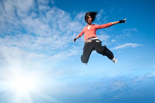 Sport woman jumping and fly over sky and sun — Stock Photo, Image