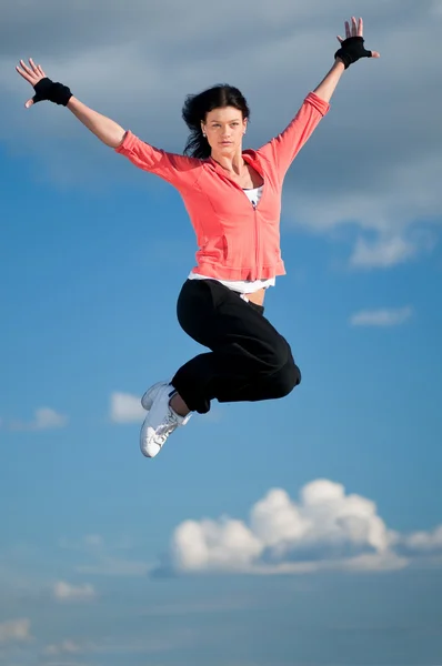 Spor kadın Jumping ve gökyüzü üzerinde sinek — Stok fotoğraf