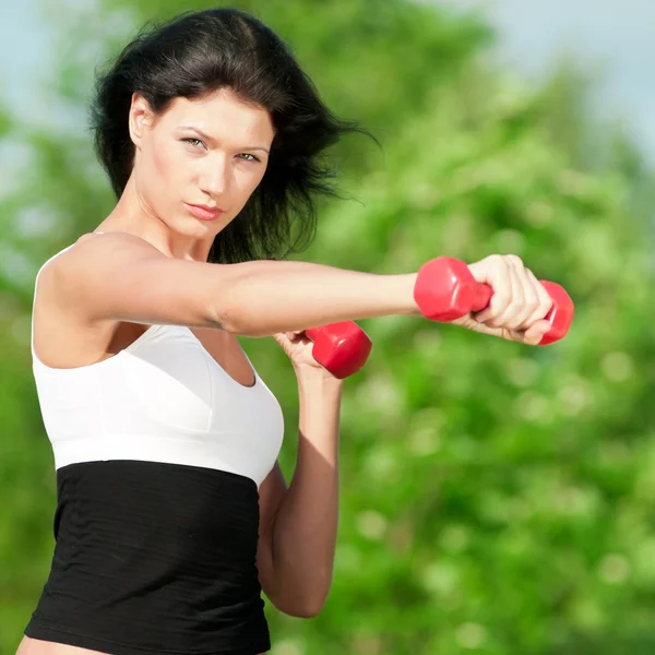 महिला डंबेलसह व्यायाम करत आहे — स्टॉक फोटो, इमेज