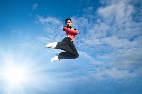 Deporte mujer saltando y volar sobre el cielo y el sol —  Fotos de Stock