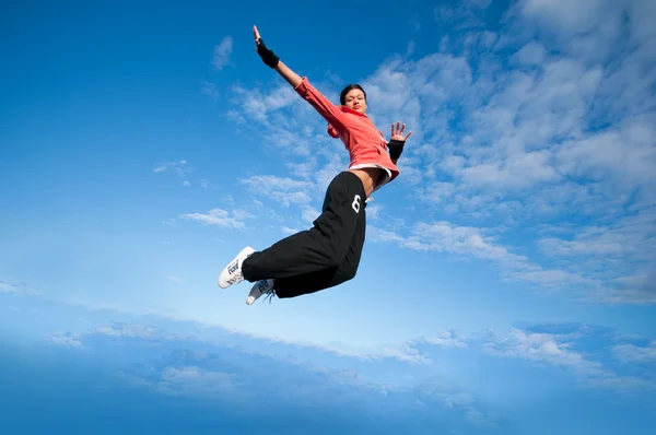 Esporte mulher pulando e voar sobre o céu — Fotografia de Stock