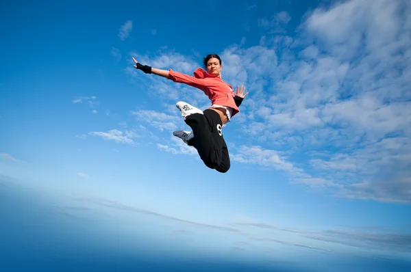 体育女子跳跃和飞翔在天空 — 图库照片