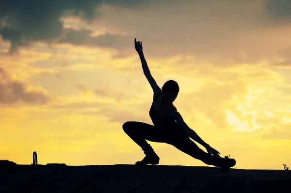 Silhouette einer tanzenden Frau bei Sonnenuntergang. Yoga — Stockfoto