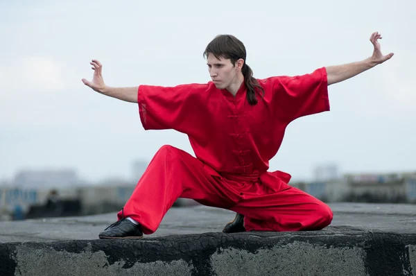 Wushoo hombre en las artes marciales práctica rojo — Stockfoto