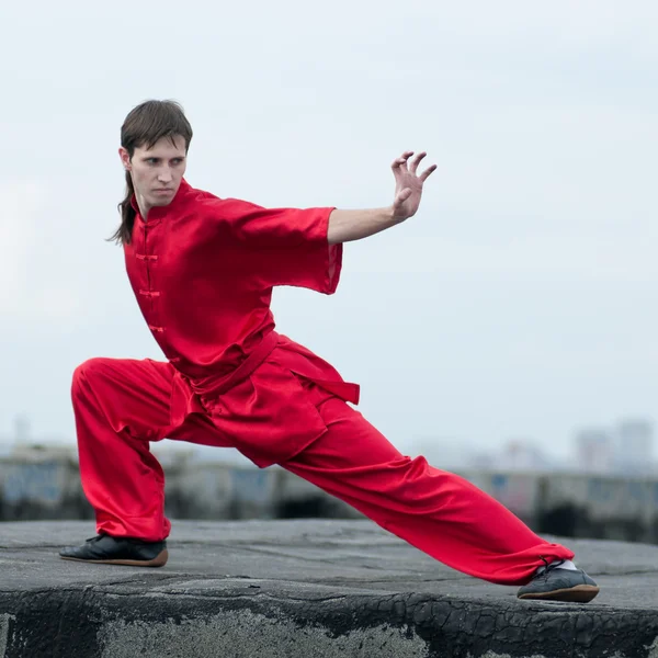 Wushoo hombre en las artes marciales práctica rojo — Stockfoto