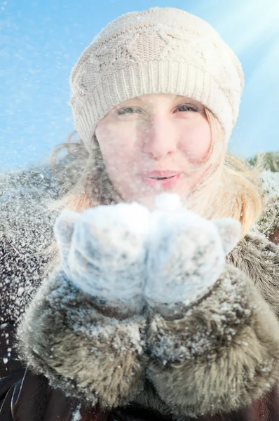 Зимняя женщина, дующая снег — стоковое фото