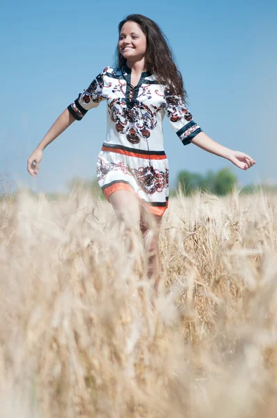 Vacker kvinna gå i vete fält på solig sommardag. — Stockfoto