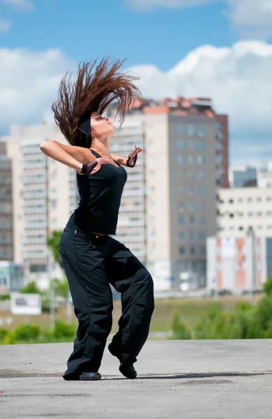 Beautiful girl dancing hip-hop over urban landscape — Stock Photo, Image