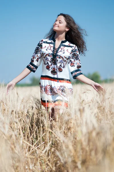 stock image Beautiful woman walk in wheat field on sunny summer day.