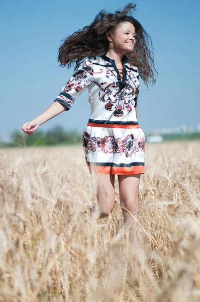 Güzel kadınla yürümek buğday alanında güneşli yaz gününde. — Stok fotoğraf