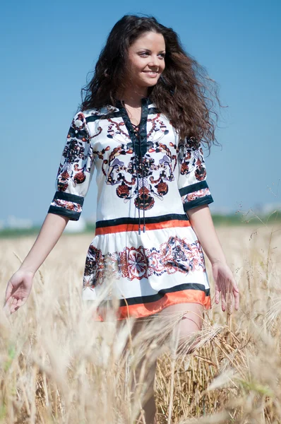 Belle femme marcher dans le champ de blé sur la journée ensoleillée d'été . — Photo