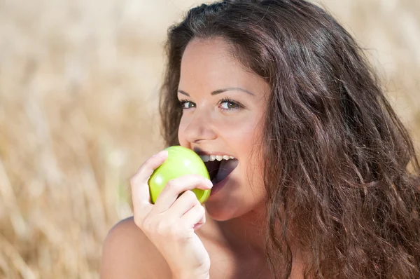 Perfect woman eating apple in dield. Summer picnic. — Stock Photo, Image