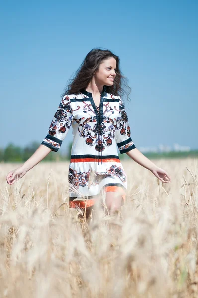 美しい女性日当たりの良い夏の日に麦畑の中を歩く. — ストック写真