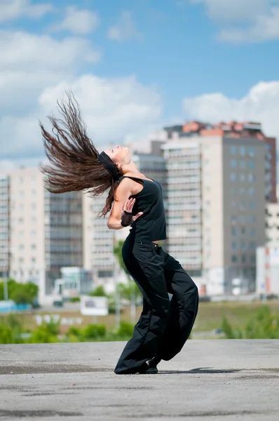 Красивая девушка танцует хип-хоп над городским пейзажем — стоковое фото