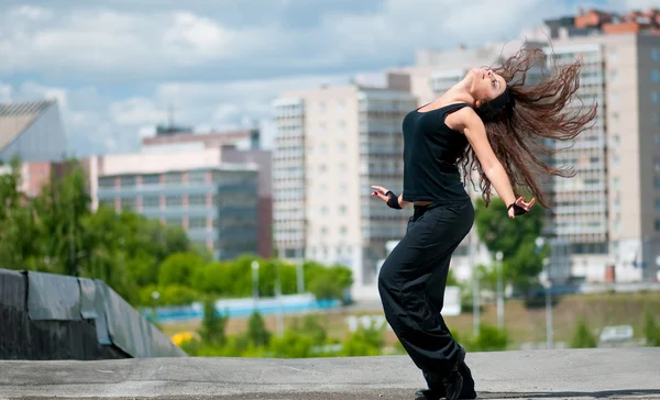 Mooi meisje dansen hip-hop over stedelijk landschap — Stockfoto