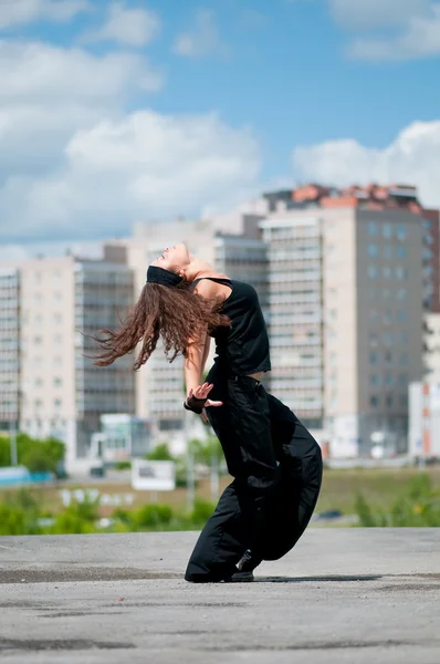 Beautiful girl dancing modern style over city landscape — Stock Photo, Image