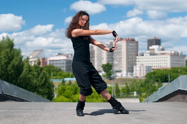 Beautiful girl dancing modern style over city landscape — Stock Photo, Image