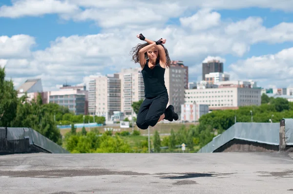 Hermosa chica bailando estilo moderno sobre el paisaje de la ciudad — Foto de Stock