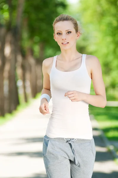 Jovem mulher correndo no parque verde Imagem De Stock