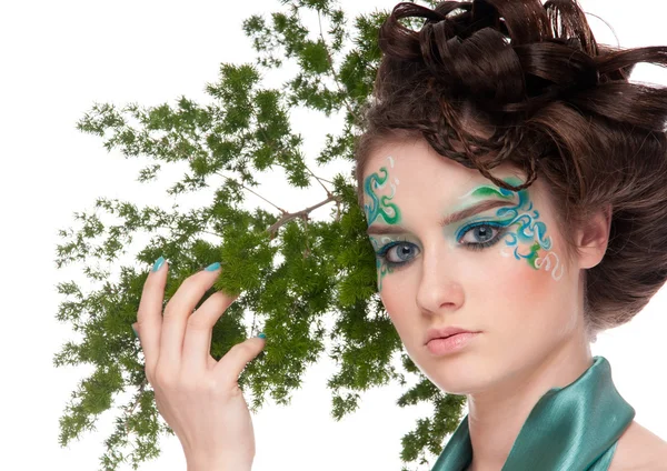 Close-up of sprite girl with faceart and plant Stock Photo