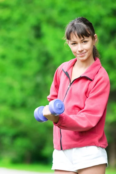 Mädchen macht Hantelübung im Freien — Stockfoto