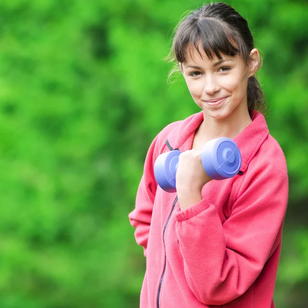 Girl doing dumbbell exercise outdoor — Stock Photo, Image