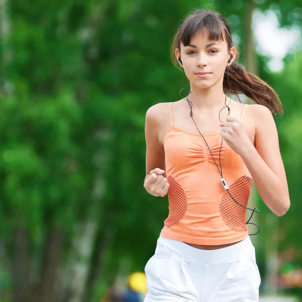 Teenage girl running in green park — Stock Photo, Image