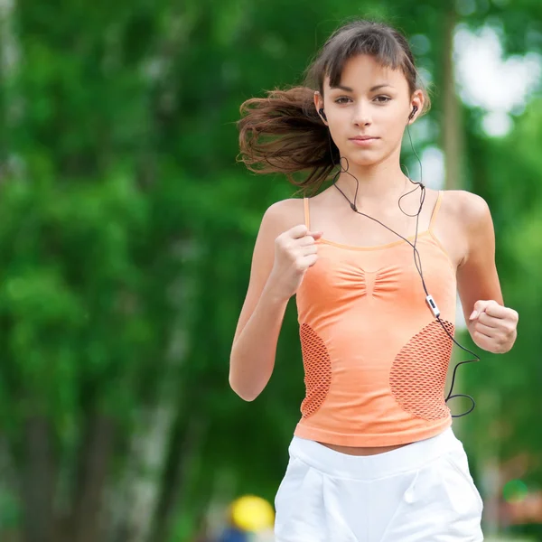 Teenage girl running in green park Stock Photo