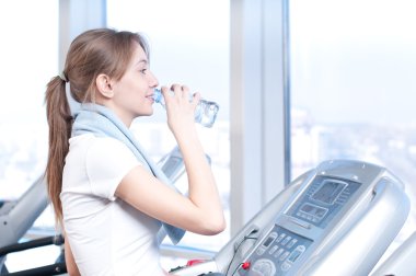 Spor egzersiz, kadın. bir makine ve içecek su çalıştırmak