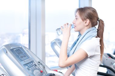 Spor egzersiz, kadın. bir makine ve içecek su çalıştırmak