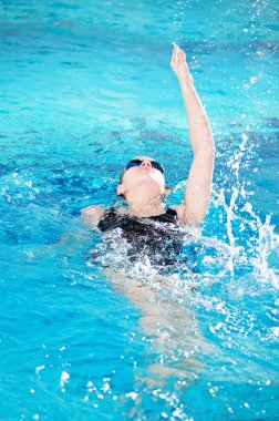 Swimmer in swim meet doing backstroke