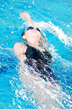 Swimmer in swim meet doing backstroke