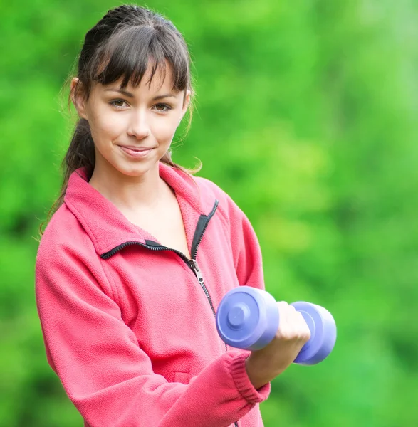 Girl doing dumbbell exercise outdoor — Stock Photo, Image