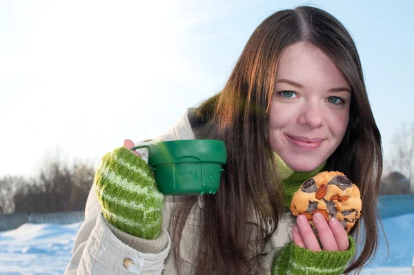 Дівчина на зимовому пікніку з чашкою трійника і печивом — стокове фото