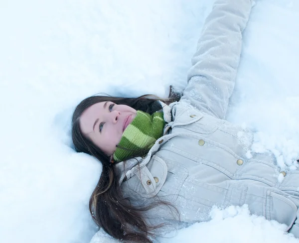 Hermosa chica en verde tumbado en la nieve —  Fotos de Stock
