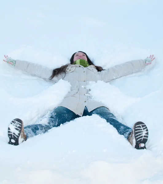 Krásná dívka v zelené ležet ve sněhu — Stock fotografie