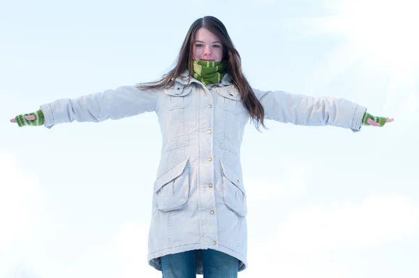 Девочка над синим зимним небом и солнцем — стоковое фото